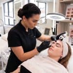 Professional beauty therapist performing soft sculpted brow treatment in salon
